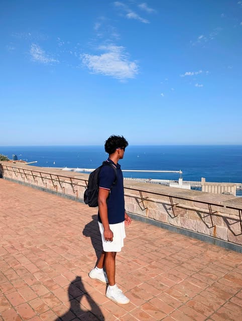 Jonathan walking beside the coast beneath a clear blue sky